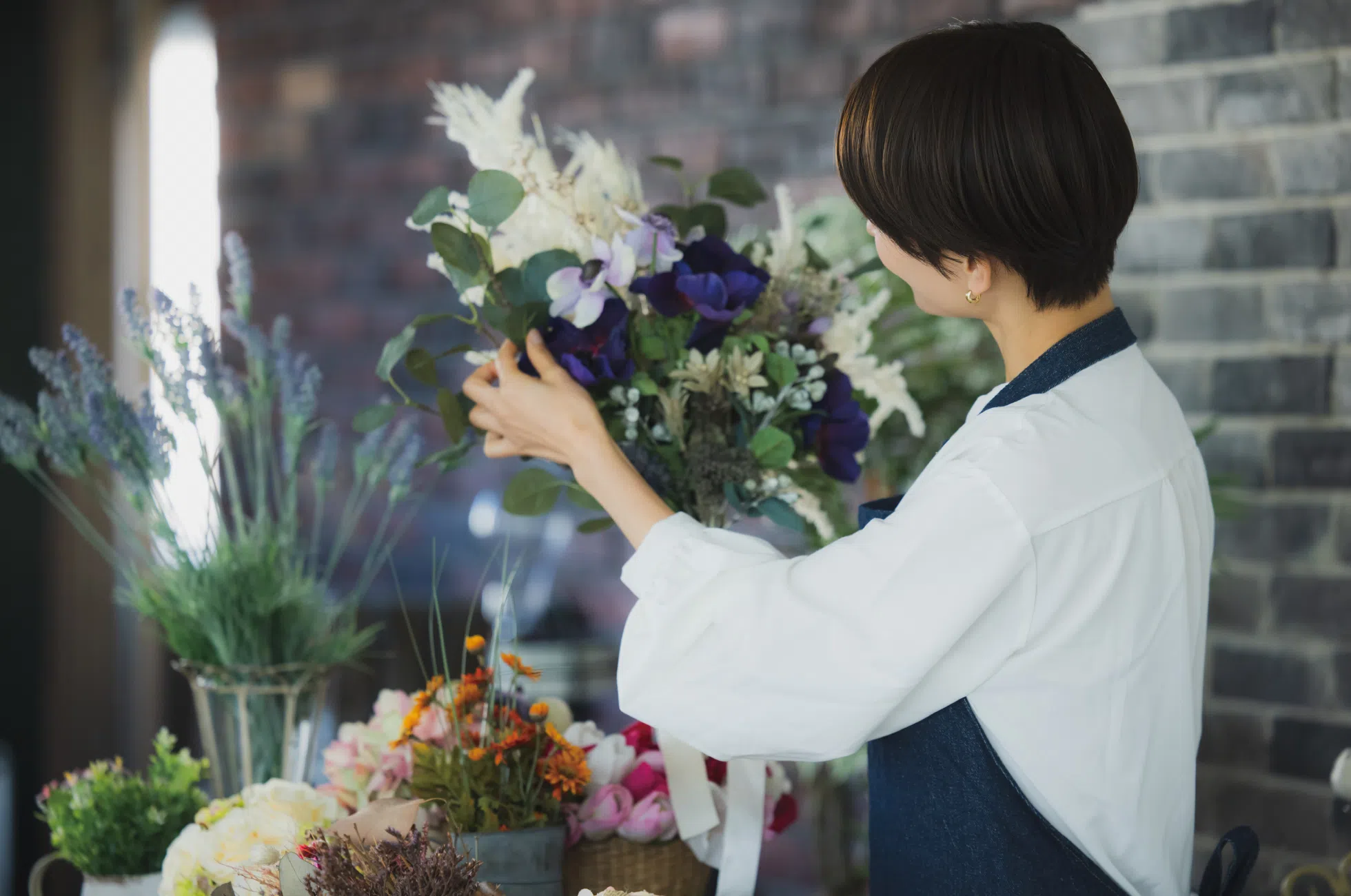 花束を誂えるフラワーショップのスタッフ