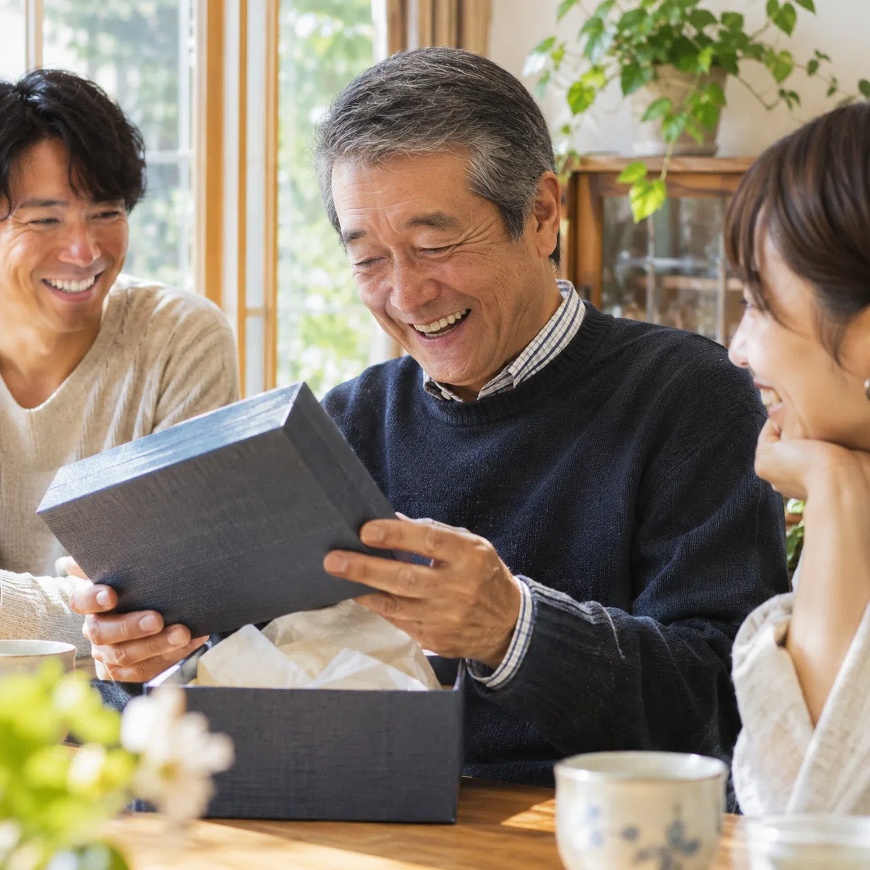 家族から贈られた退職祝いのプレゼントを開け、驚きと喜びで満面の笑顔になる父