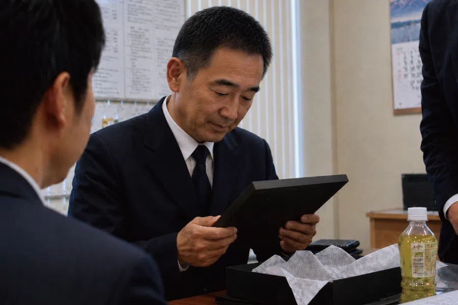 警察官の退職祝い記念品を手に取り見つめる場面