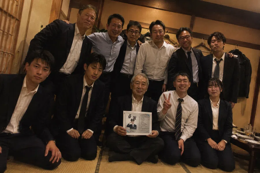 警察署の仲間と記念品を囲んで撮影した集合写真
